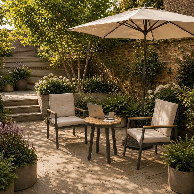 Outdoor patio with two chairs, a table, and an umbrella in a garden setting.