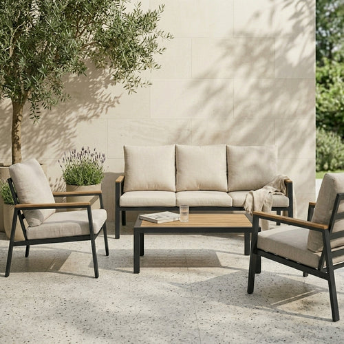 Outdoor patio set with sofa, chairs, and coffee table against a beige wall.