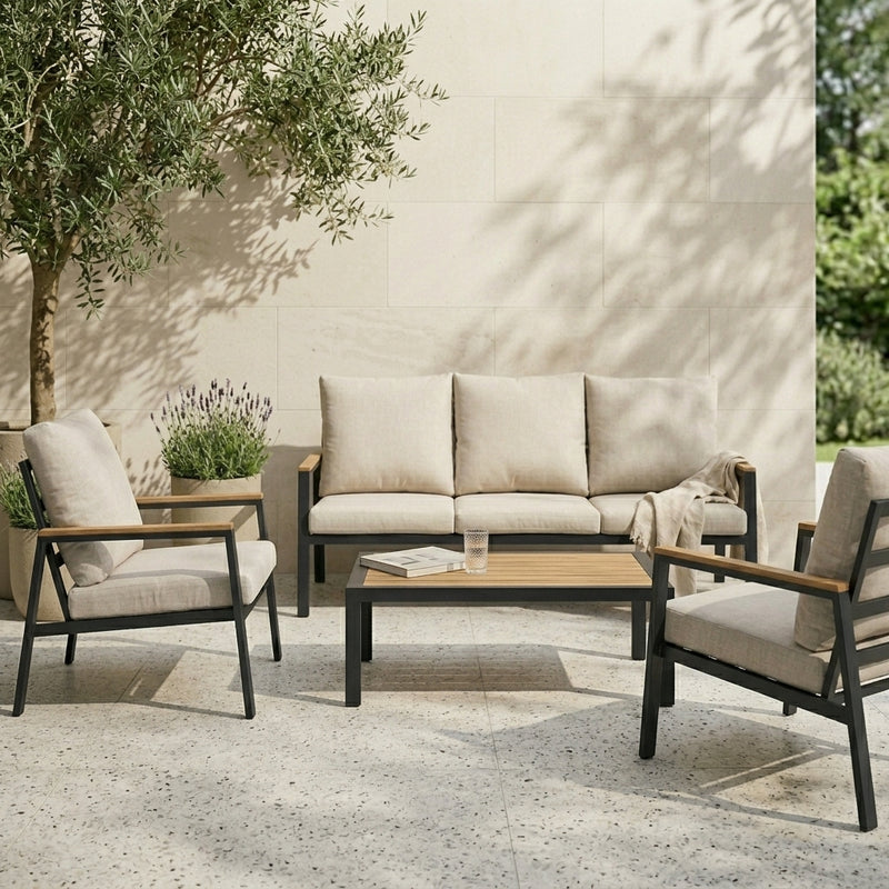 Outdoor patio set with sofa, chairs, and coffee table against a beige wall.