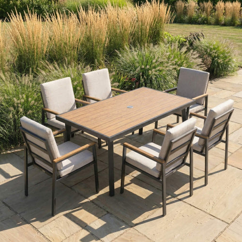 Garden dining set with a wooden table and six chairs on a stone patio.