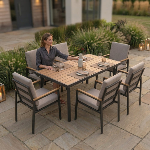 Woman sitting at an outdoor dining table with chairs on a patio
