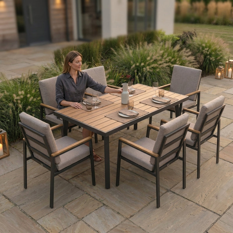 Woman sitting at an outdoor dining table with chairs on a patio