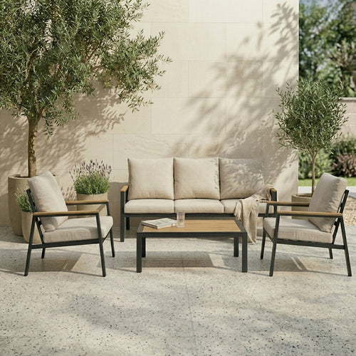Outdoor patio set with sofa, chairs, and coffee table on a stone patio.