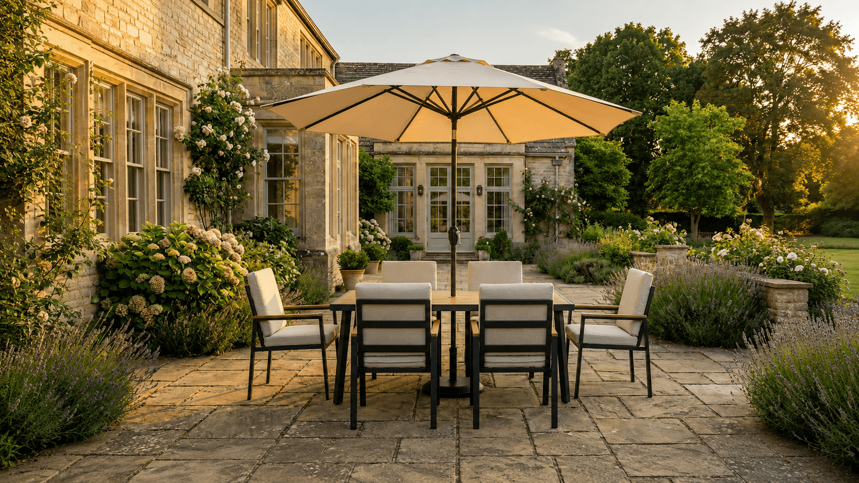 Patio set with table and chairs under a large umbrella in front of a stone building.